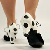 A pair of women's shoes with black and white polka dot pattern on the upper, featuring a suede covered toe and a rubber outsole.
