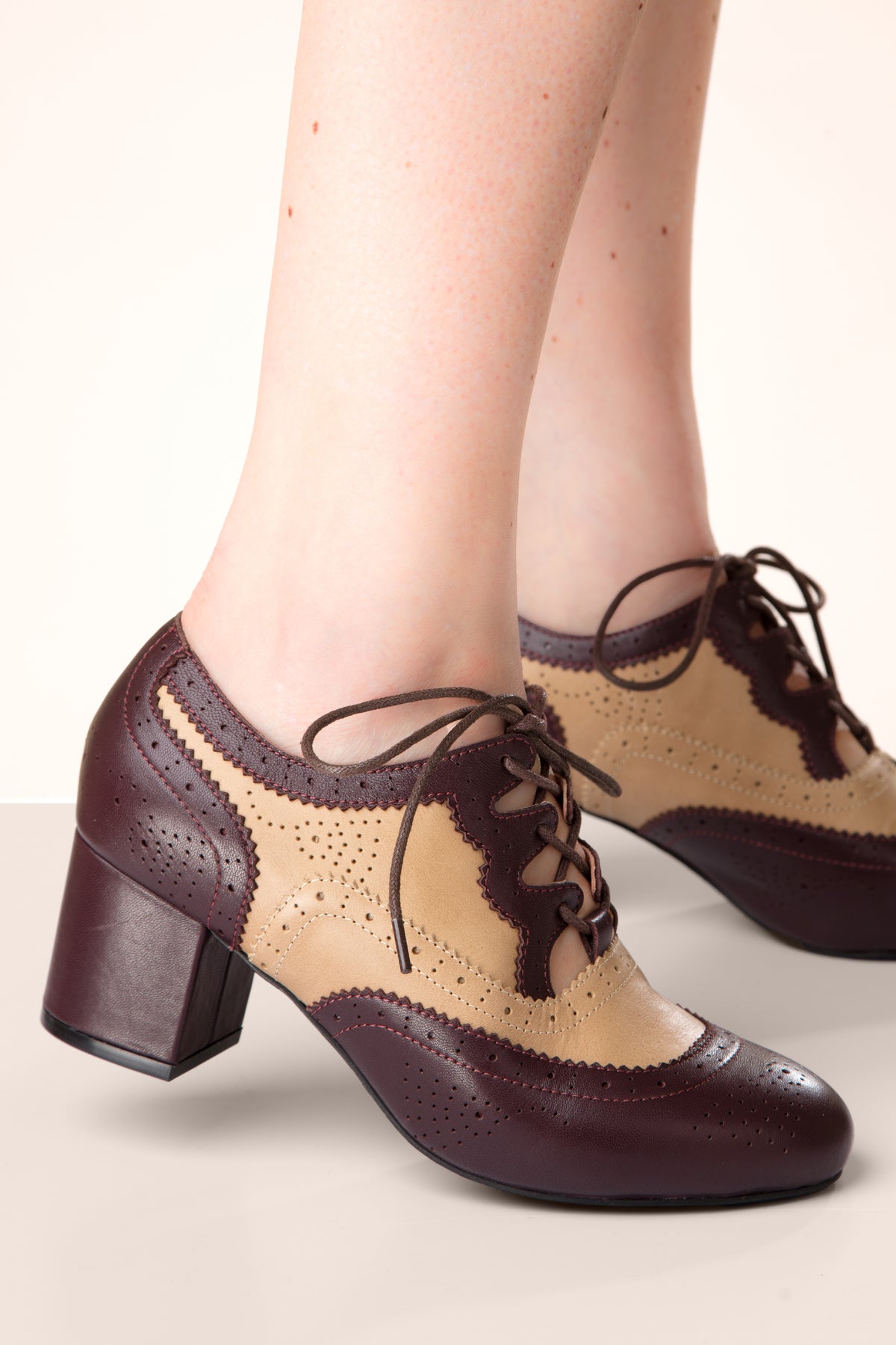 Pair of brown and beige brogue shoes on a light background